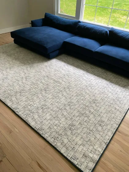 Ivory and grey area rug in a sunlit living room with a navy sectional