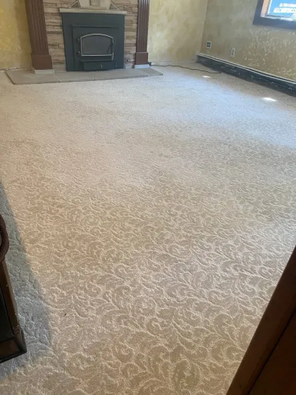 Patterned cream carpet in a living room with a brick fireplace