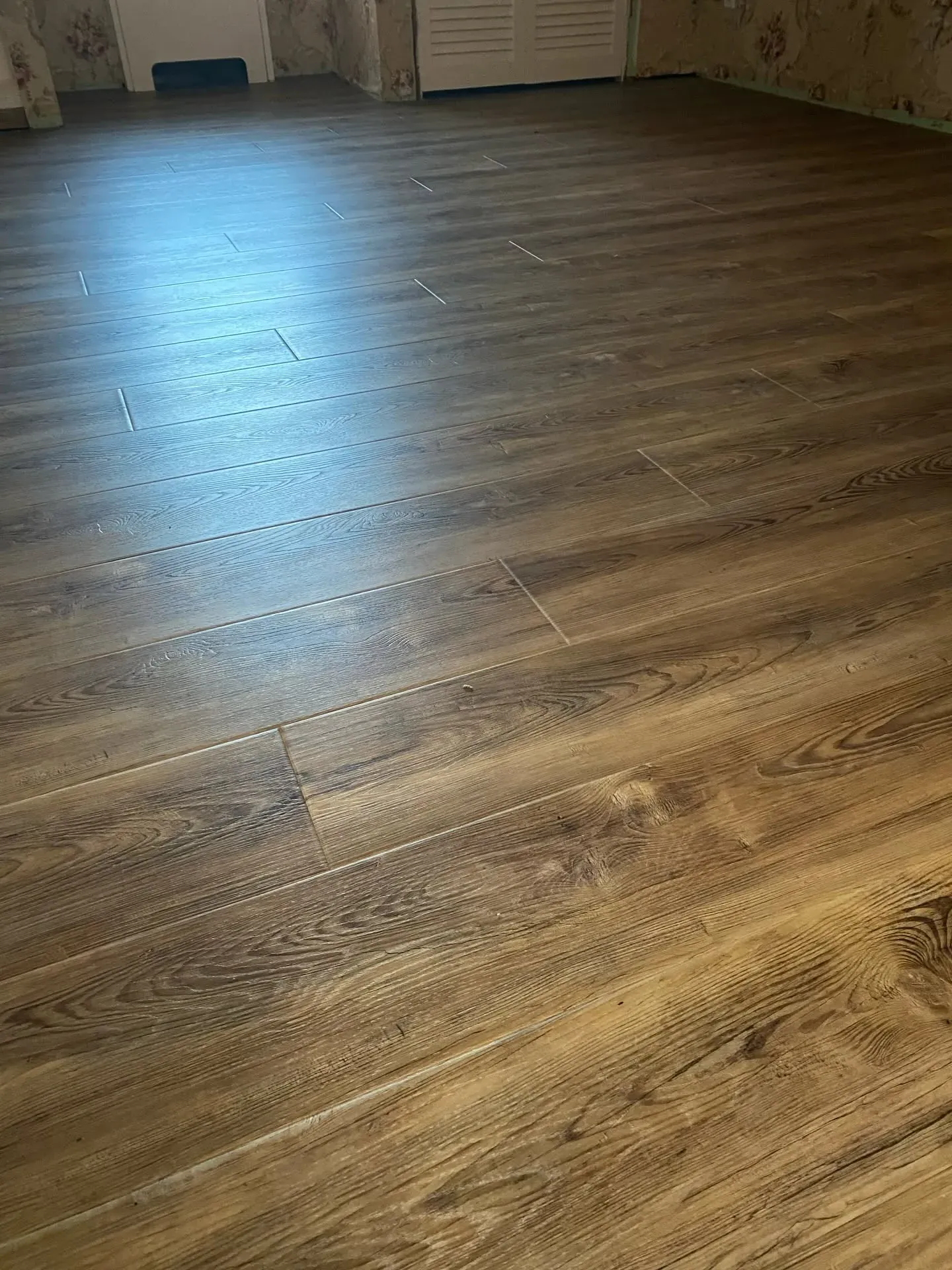 Dark wood-look luxury vinyl plank flooring installed wall to wall
