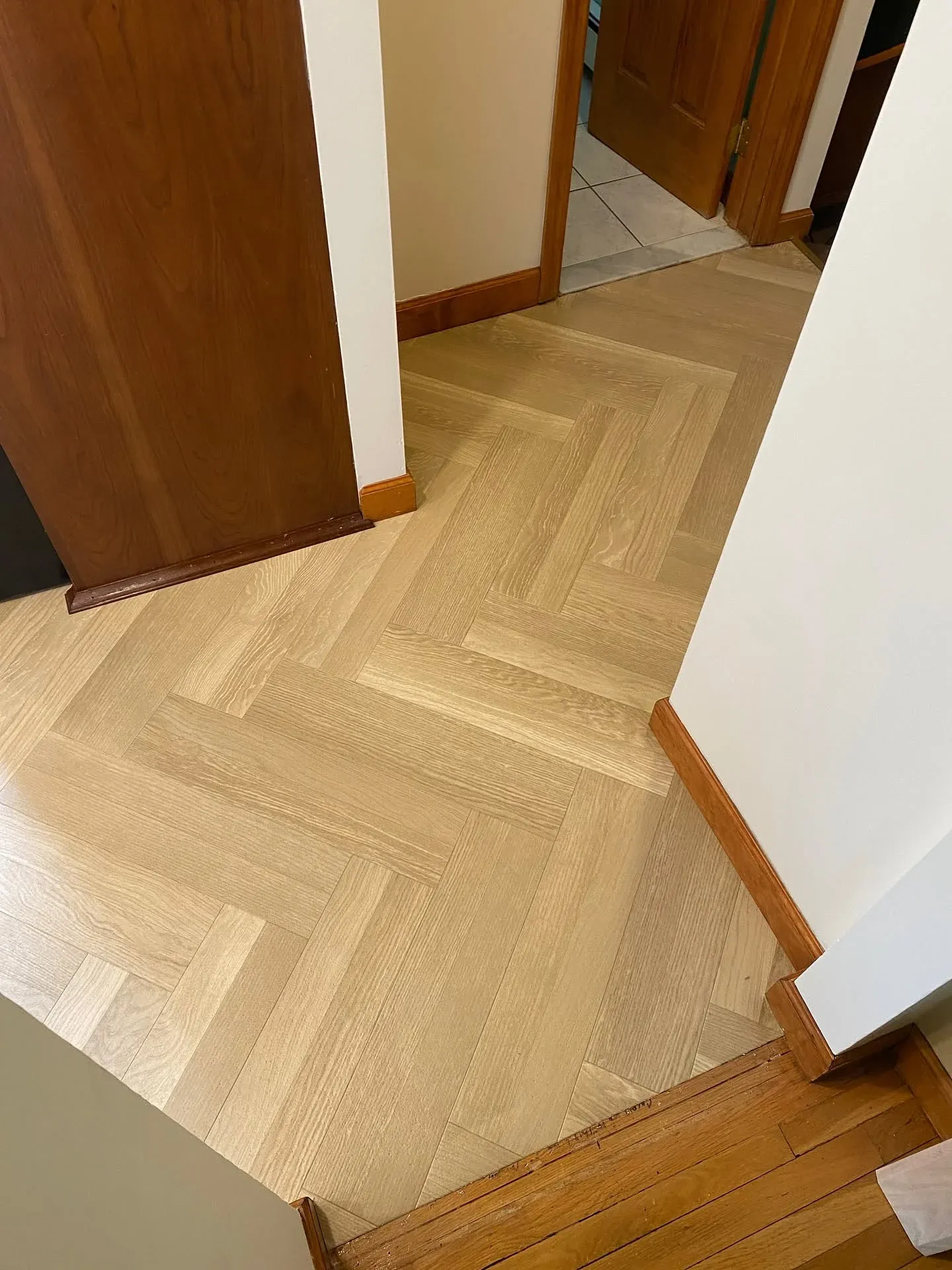 Light oak herringbone luxury vinyl plank installed in a hallway
