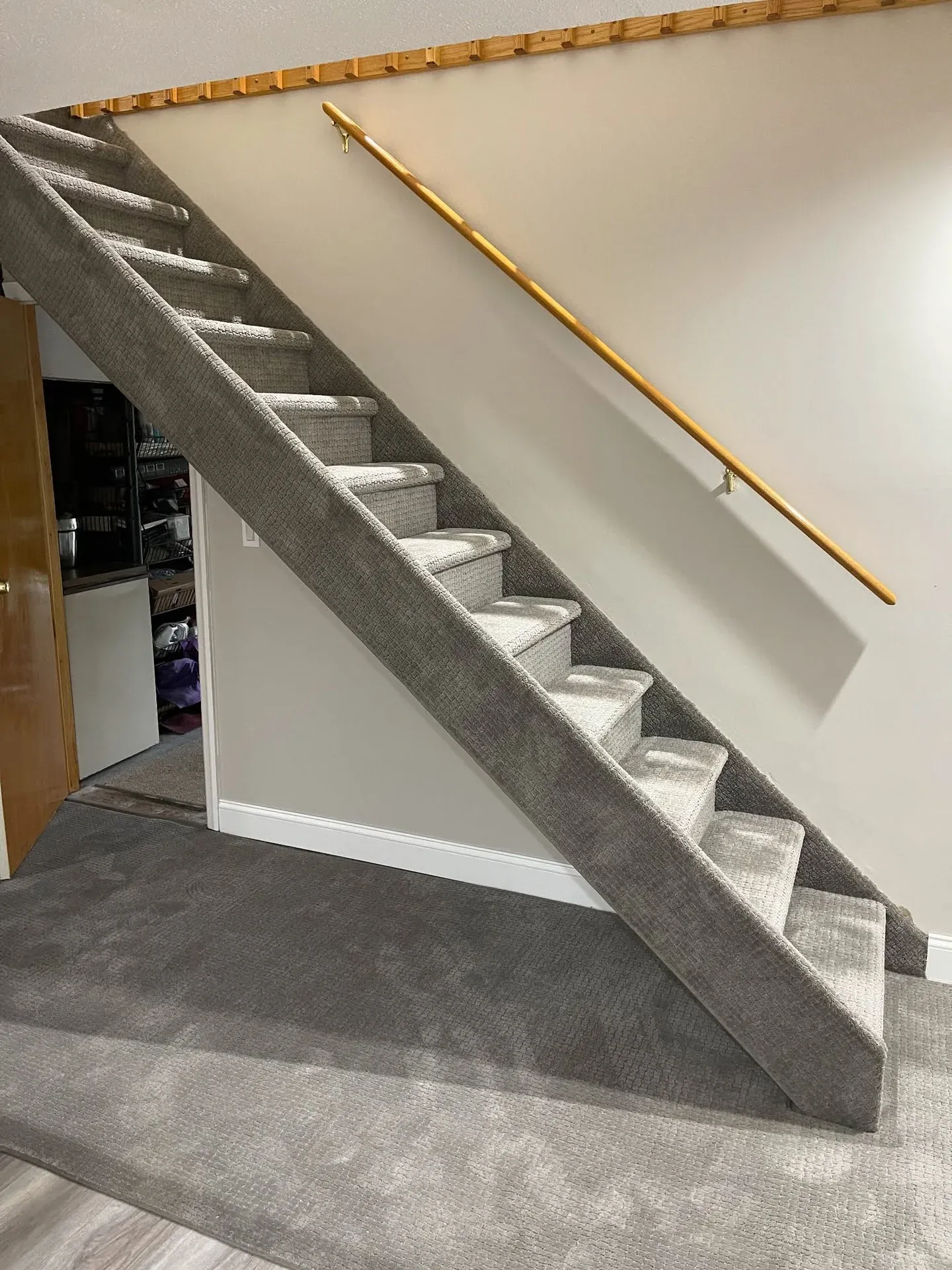Grey carpet installed on an open-stringer staircase and basement floor