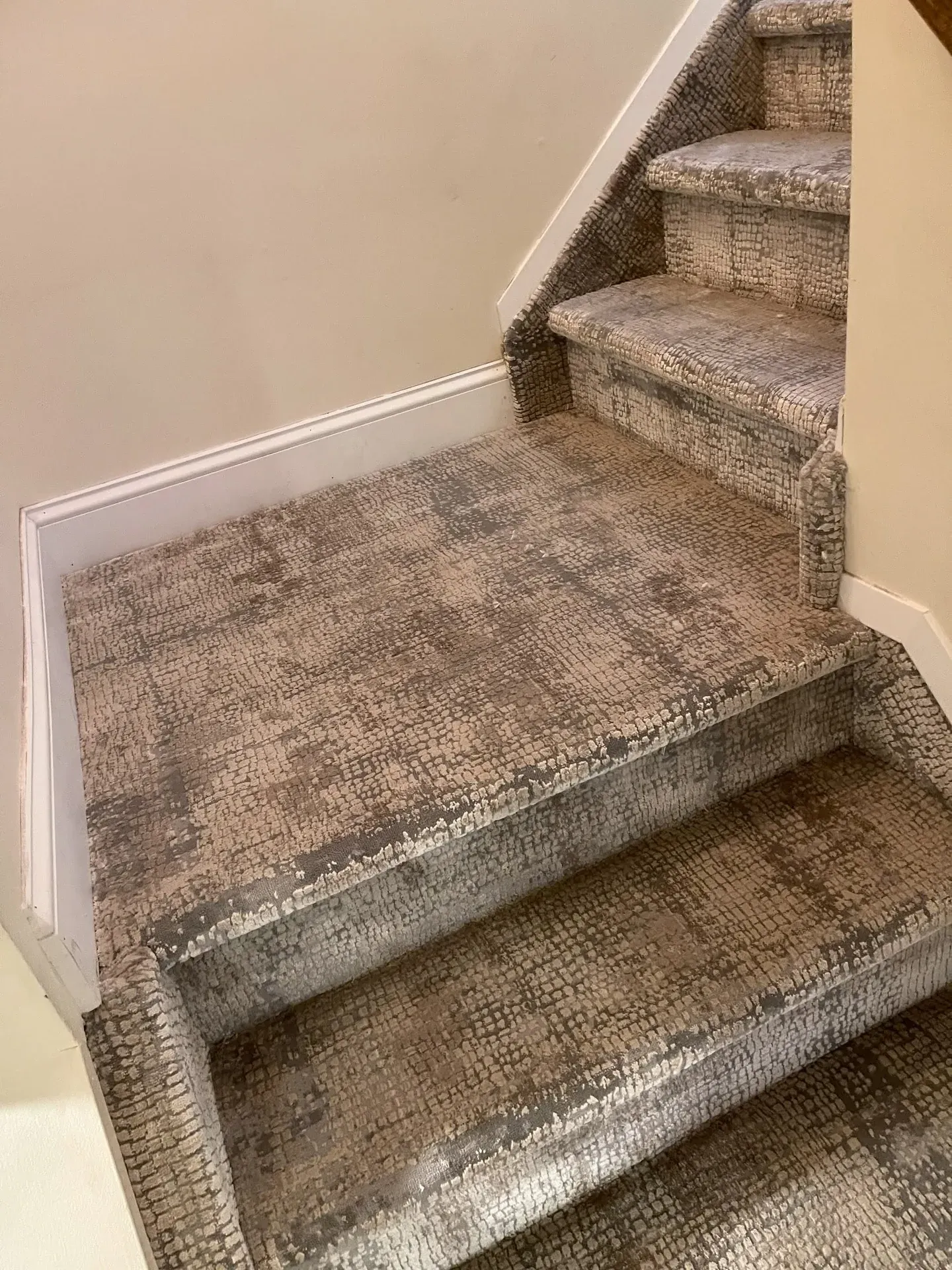 Textured grey carpet wrapped over winding stair treads