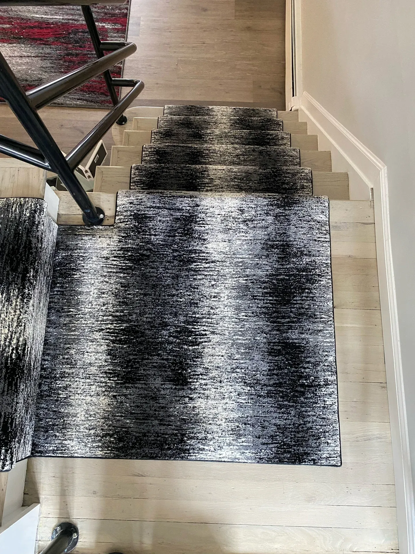 Stair runner and matching area rug on light plank flooring