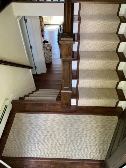Cream stair runner installed on a hardwood staircase and landing