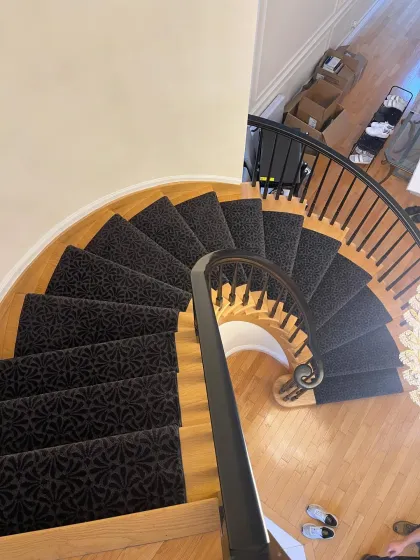 Dark patterned stair runner installed on a curved staircase