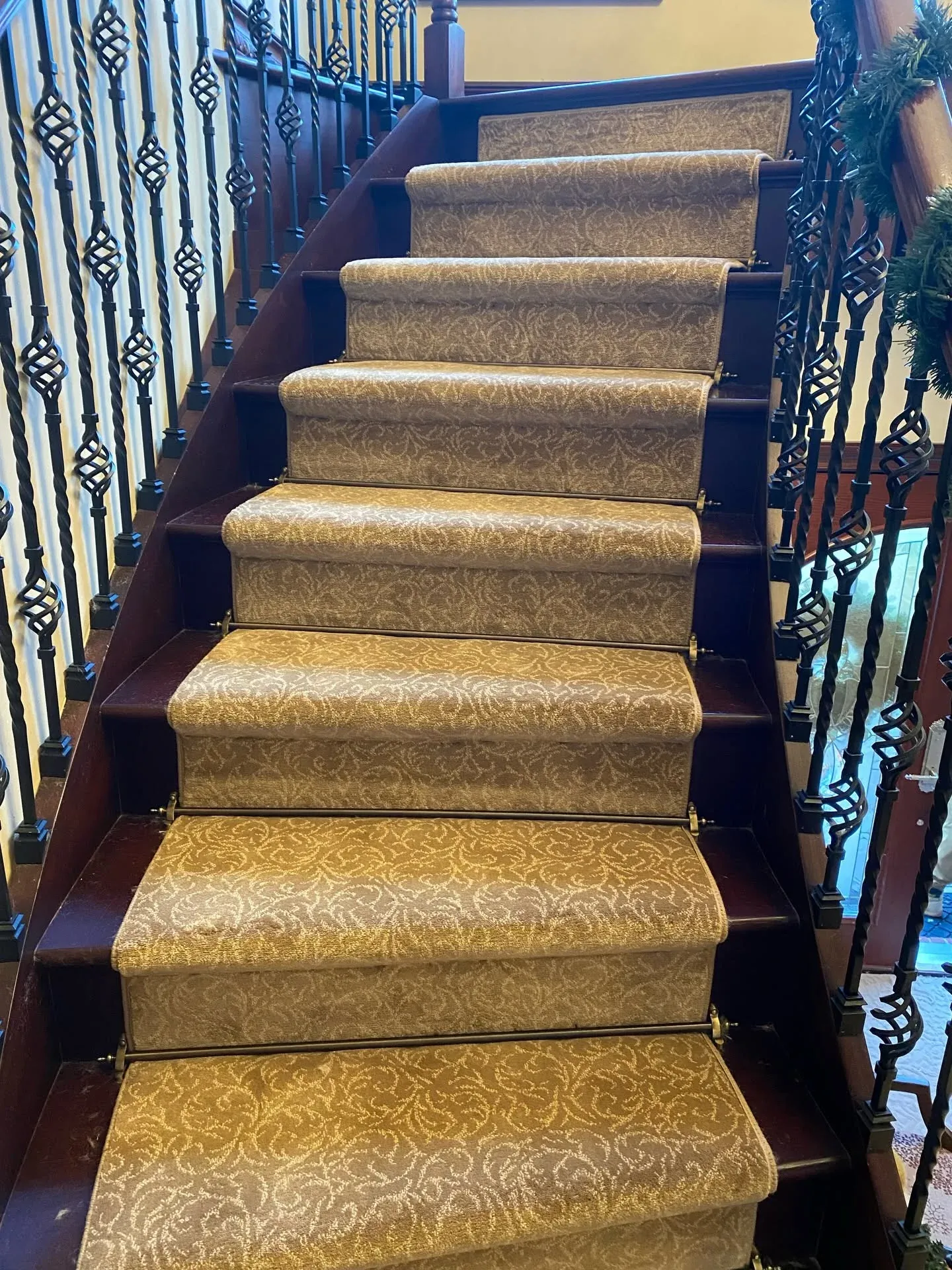 Patterned stair runner on a staircase with wrought-iron balusters