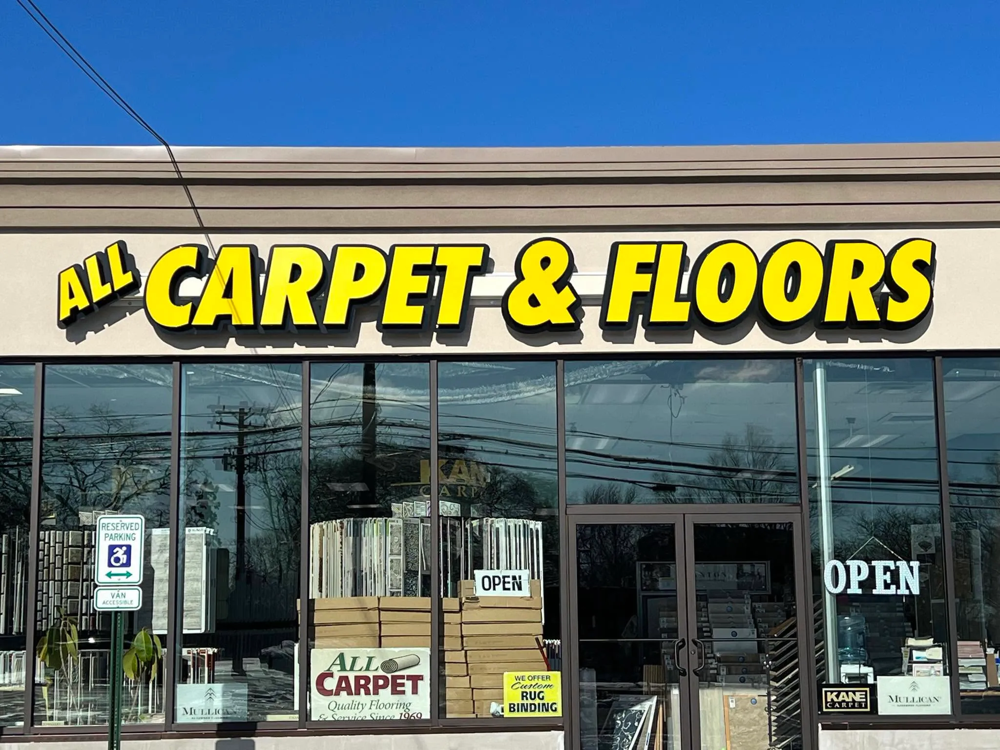 The All Carpet & Floors storefront on Jericho Turnpike in Commack, its yellow sign above the showroom windows